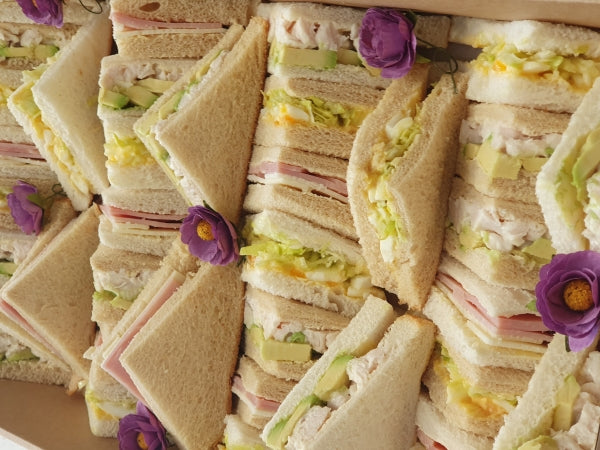 A platter of delicious sandwiches with simple fillings like egg, ham and salad